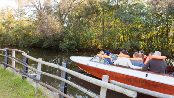 people sitting in a boat with life jackets on in the river